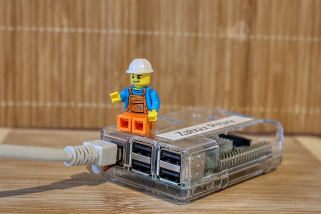 A Lego figurine fashioned as a construction worker sits on top of a Raspberry Pi computing device